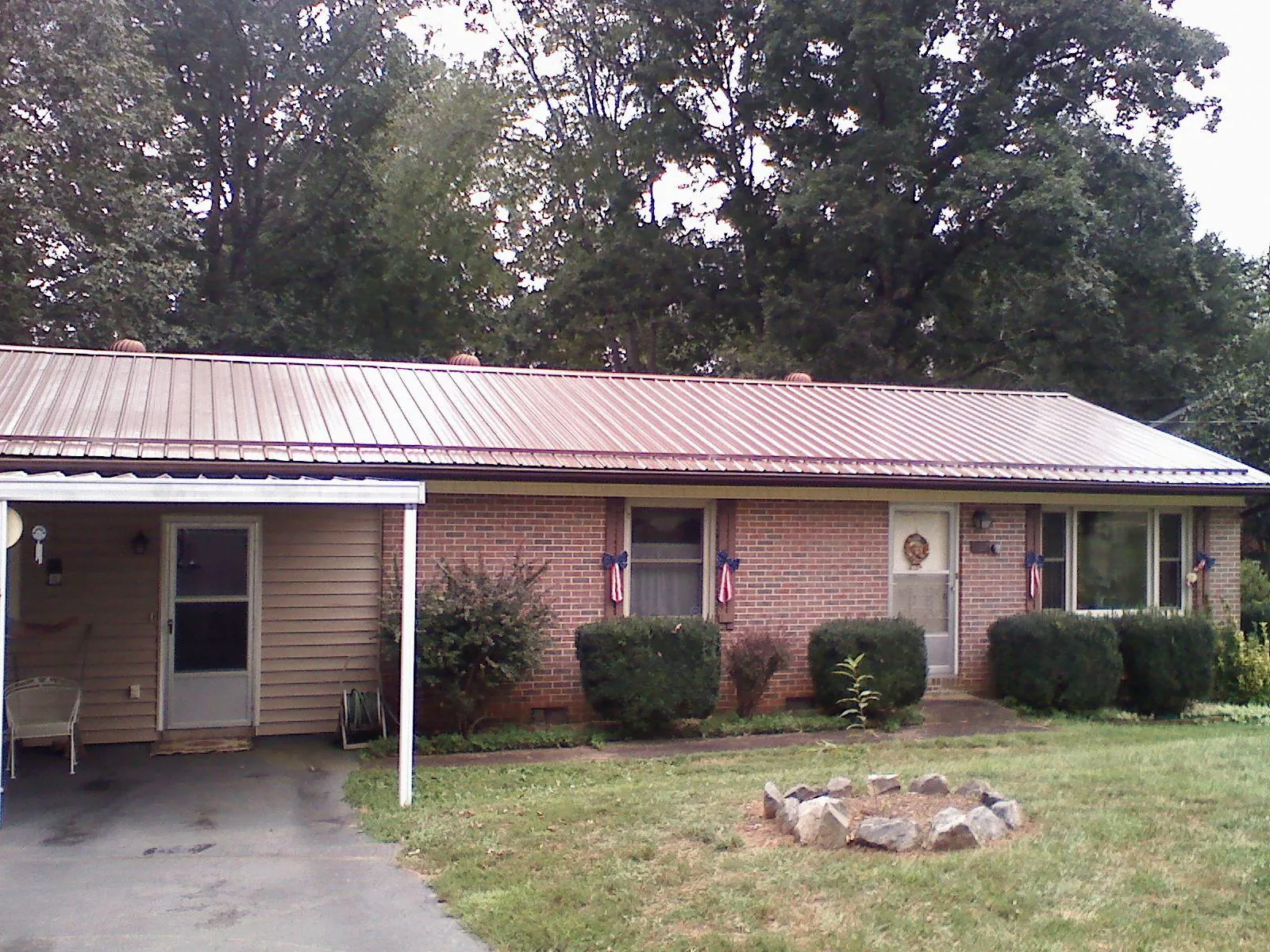Bronze metal roof and carport on a brick ranch home — Roof Repair work by our crew in Tidewater