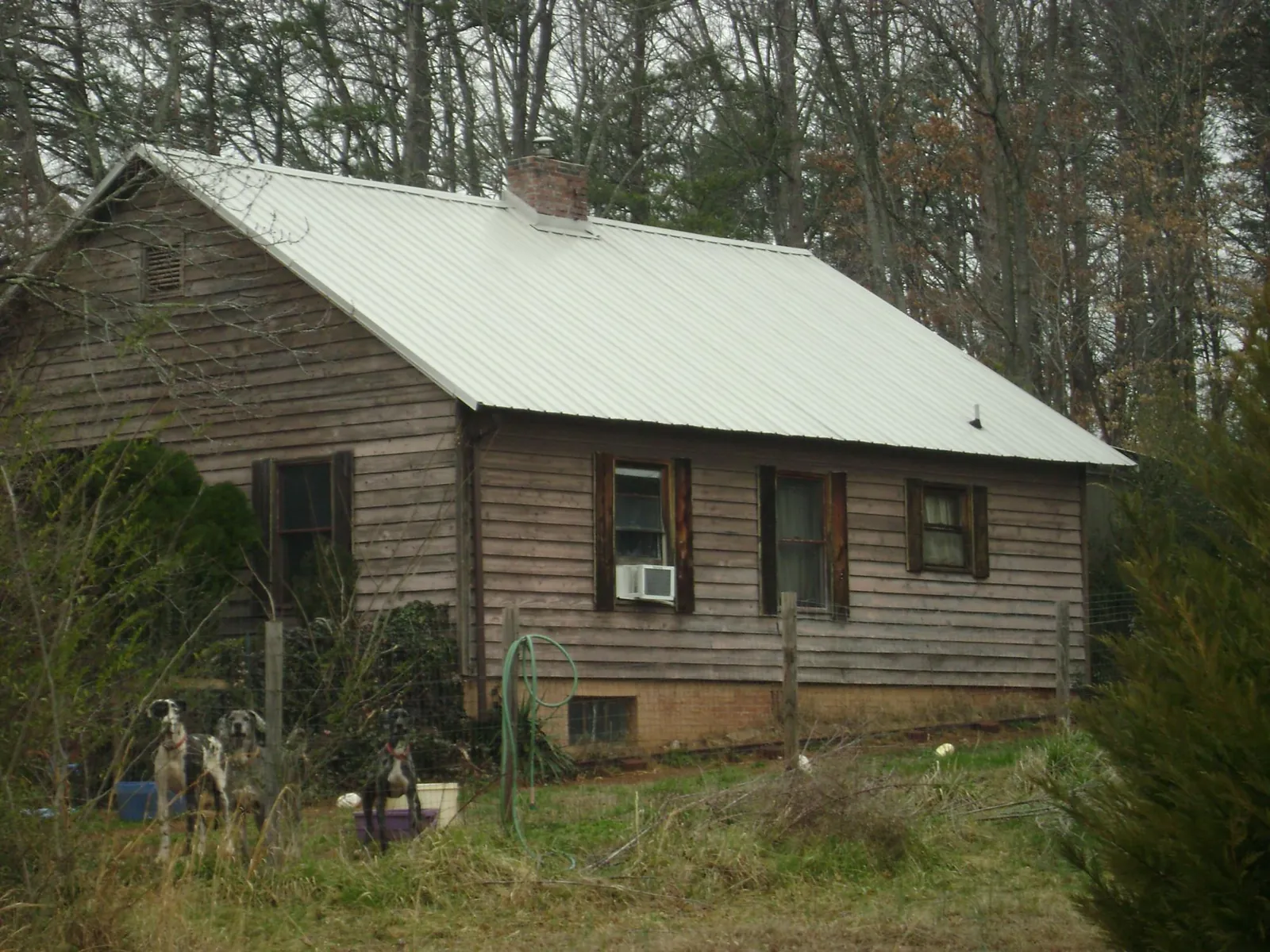 White metal roof on an old wood sided farmhouse, from a Metal Roof Installation job in Tidewater
